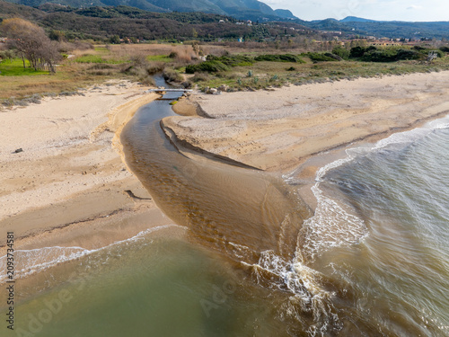Aerial View of Small River Flowing into the Sea on a Sandy Beach Coastline in Corfu Greece