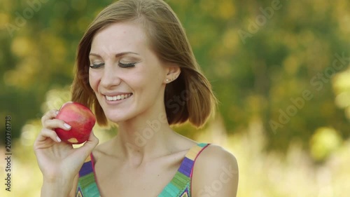 Young beautiful woman eating ripe red apple