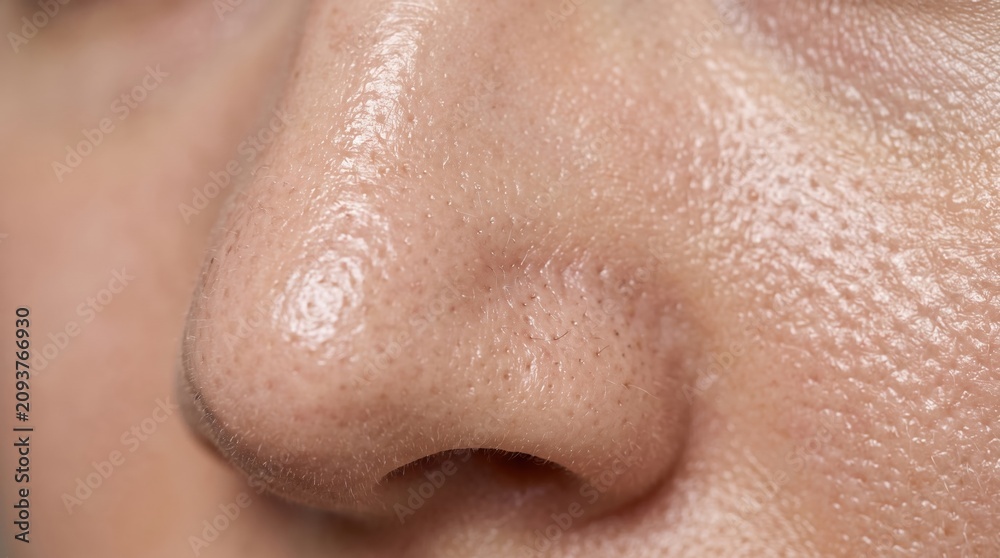 Fototapeta premium Detail of nose skin pores and blackheads reflecting light on oily face surface with blackheads skincare dermatology