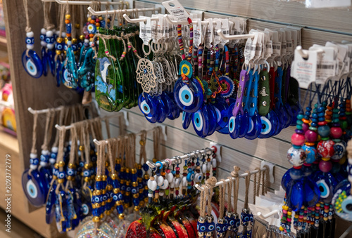 Display of traditional Turkish evil eye nazar amulets, keychains and handmade souvenirs in a local gift shop. Popular travel souvenirs and symbols of protection in Turkish culture