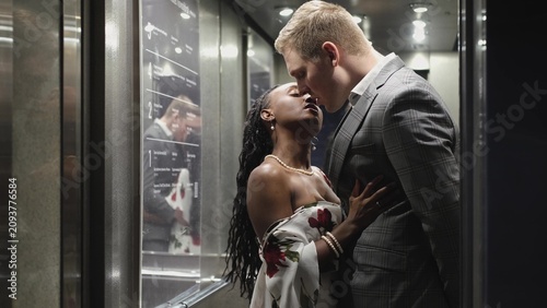 Photos A handsome young man and a beautiful woman look at each other and smile while standing in an elevator
