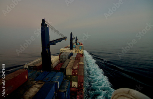 Foto Container ship underway at sea in the evening after sunset