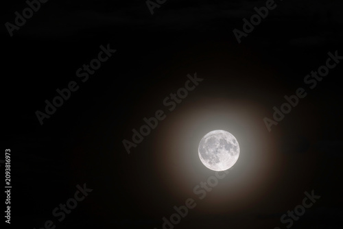 full moon glowing through dark night sky