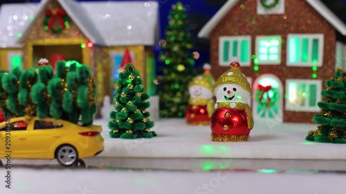 Christmas Miniature Scene with Toy Yellow Car Carrying Trees and Wind-up Santa Claus