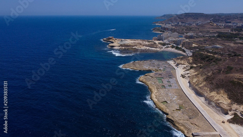 Fotografia Xwejni s centuries-old salt pans unfold along the rugged coast of Zebbug, Gozo,