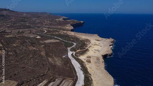Fotografia Xwejni s centuries-old salt pans unfold along the rugged coast of Zebbug, Gozo,