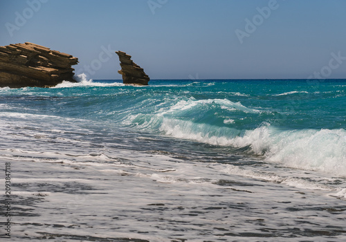 Foto A landscape with waves of the blue Mediterranean Sea crashing onto a sandy beach