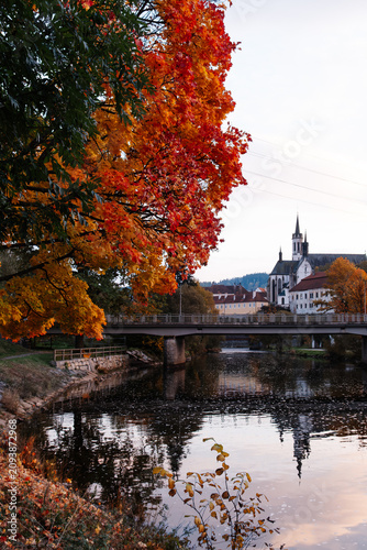 Historic monastery by river in autumn town landscape