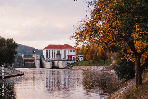 Hydroelectric dam in autumn landscape at sunset