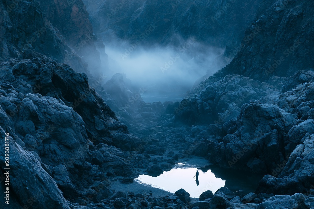 Fototapeta premium Frost-Rimmed Volcanic Rocks in Fjord Inlet at Blue Hour Dawn