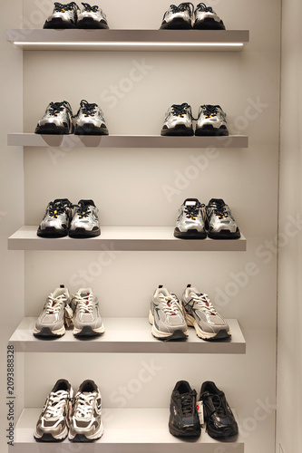 Minimalist sneaker display on retail shelves in modern clothing store