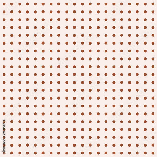 Seamless organic mini polka dot pattern with warm burnt sienna dots on a soft dusty rose cream background. Perfect for boho nursery wallpaper, bedding, and cozy fabric. Vector illustrating