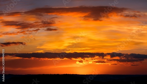 Panoramic Sunset Sky With Warm Golden Orange Hues And A Dark Band Of Clouds On The Horizon Romantic Evening Landscape