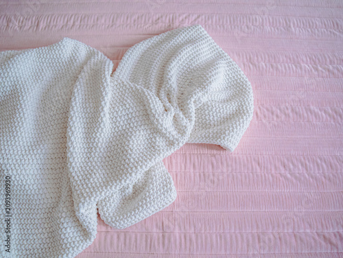 Quadro su tela The folded knitted-yarn blanket with a textured stitch pattern lies on the quilted fabric bedspread on the bed in the bedroom