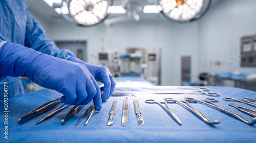 Schilderij op canvas Surgeon Preparing Surgical Instruments for an Operation in Hospital
