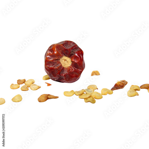 Dried date fruit and scattered date seeds on white background
