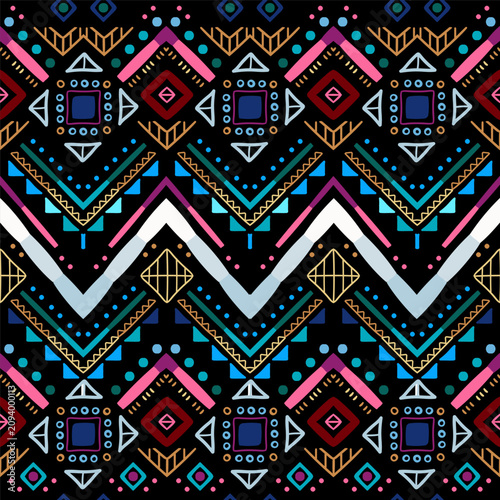 Zigzag tribal chevron seamless pattern. African, Aztec. Geometric vector oriental background. Multicolor backdrop with triangles, dots, and diamonds. Mayan Lines, stripes.