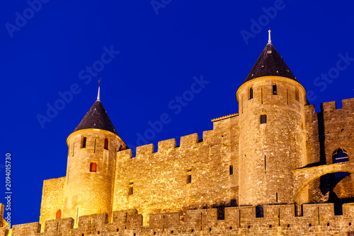 Tableau sur toile Closeup of Medieval fortress towers on hill in Carcassonne France illuminated at