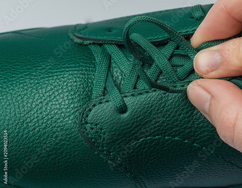 Adjusting Laces on Green Leather Shoe Close-up Hand View Intimate Detailed Texture Composition Lifestyle