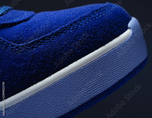 Close-up View of Blue Sneaker Toe with Textured Surface and White Accents in a Simple Environment