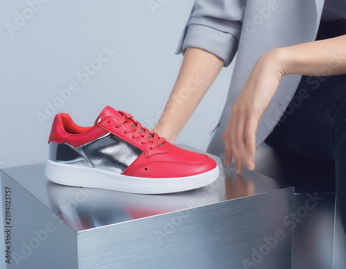 Red Shoe on Metallic Surface with Person's Arm, Luxury Fashion Product View
