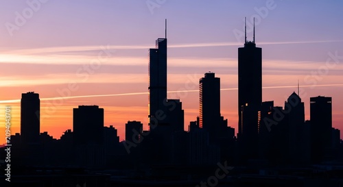 Cityscape silhouette at sunset with pastel sky and clouds