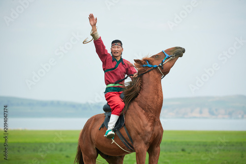 Quadro su tela Mongolian men on horseback at the Naadam Festival on the grassland