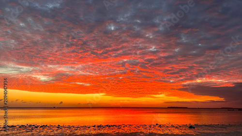 Stunning morning sky painted with vivid red and orange clouds above a calm sea