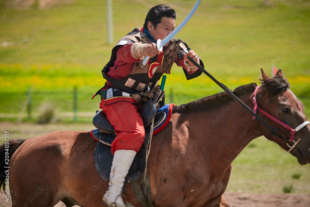 Obraz premium A Mongolian ancient horseback battle performance at the grassland scenic area