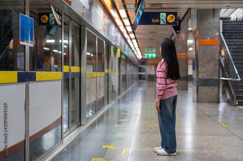 Obraz na płótnie Asian child or kid girl waiting sky train or electric train with underground rai