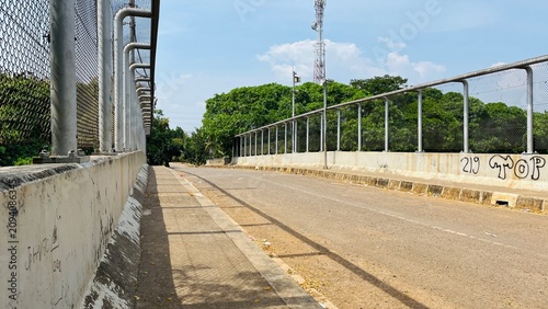 Empty asphalt road on an overpass bridge structure under a clear blue sky