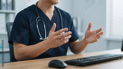 Bild auf Leinwand doctor hand writing medical report on clipboard and reviewing patient document at hospital office with laptop