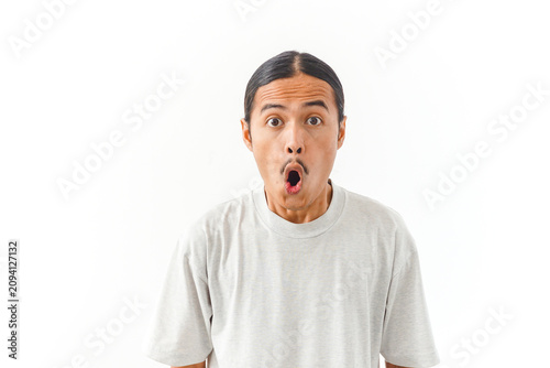 Konstfotografi Surprised Asian man with wide open mouth looking at camera