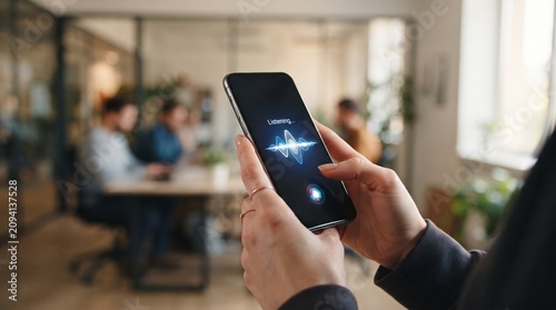close up of hands holding smartphone with ai voice assistant screen