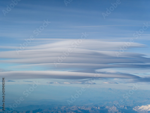 Stunning aerial view of UFO-shaped lenticular cloud formations over a mountain range