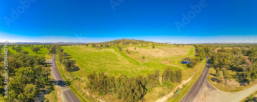 A panoramic shot of roads surrounded by trees and grass in Australia