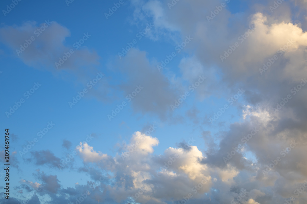 Obraz premium Bright Blue Sky with Large White Cumulus Clouds. Scenic view of large cumulus clouds floating across a bright blue sky. Perfect natural background representing peaceful weather and fresh summer air.