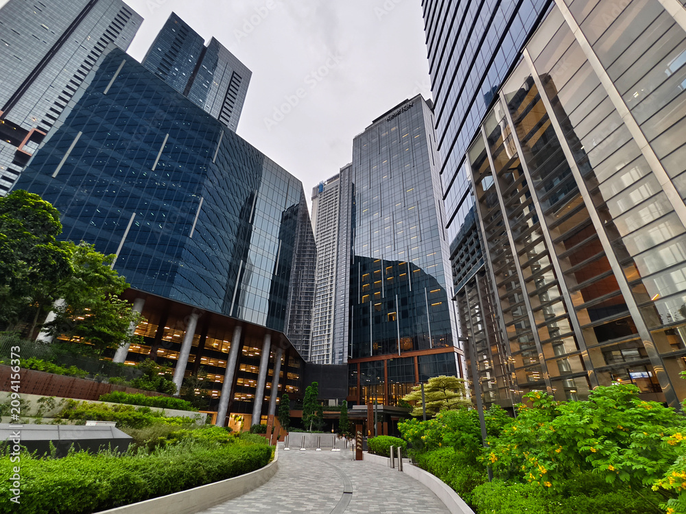 Obraz premium Ground level plaza with columned entrance, inviting steps and greenery frame office lobby.