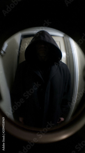 Hooded Figure Seen Through Apartment Peephole at Night