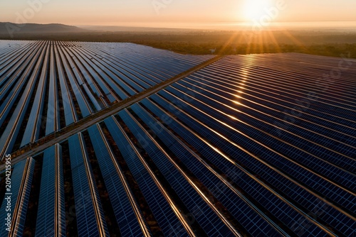 Aerial drone view of large solar farm perfect rows of dark pa