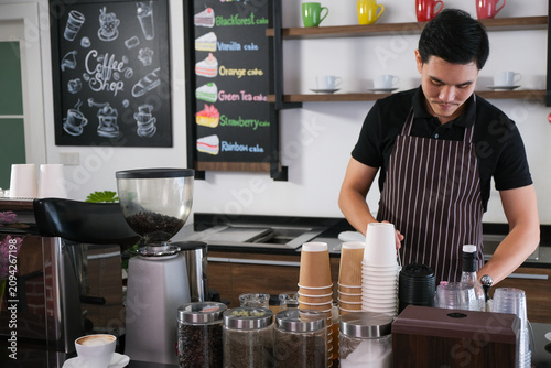 Barista coffee cafe cup counter apron machine beverage preparing drink behind counter with calm focused expression