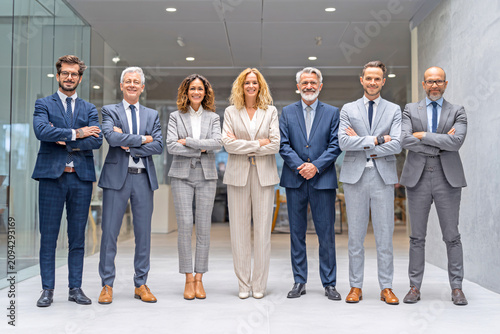 Professional business team standing confidently in modern office
