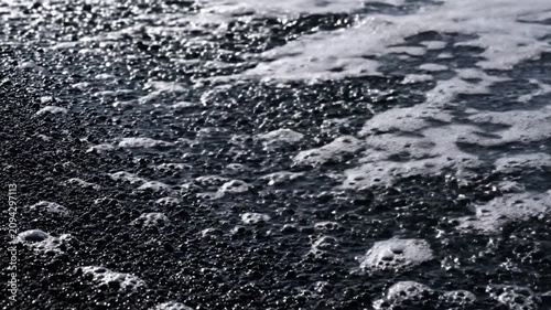Waves Crashing onto a Dark Sandy Beach in a Video Sequence