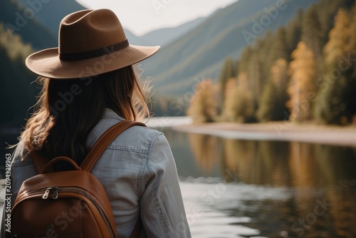 woman traveler with backpack holding hat