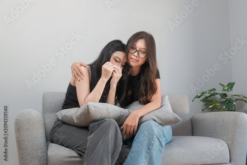 Supportive Young Asian Woman Embracing Her Sad Friend During a Difficult Moment