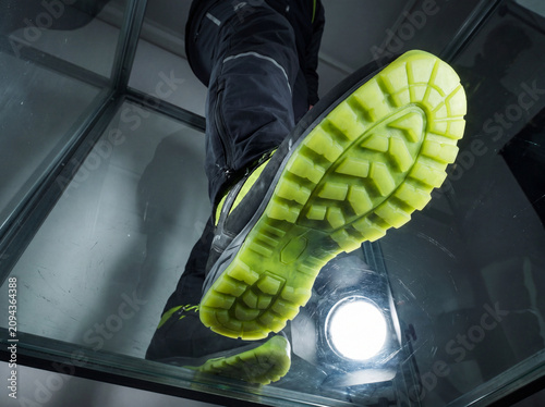 Dynamic Close-up of Foot on Glass Floor with Athletic Shoe in Movement