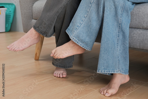 Bare Feet of Two Young Women Relaxing Together at Home