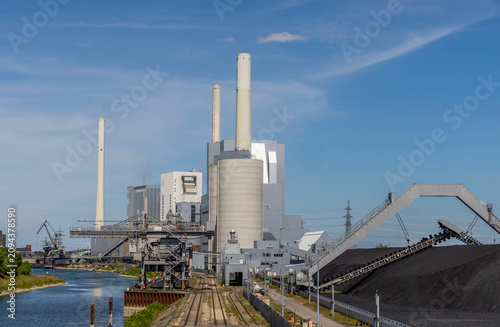 Power station beside the River Rhine in Mannheim, Germany, generating electricity from fossil fuels within a large industrial and environmental landscape.