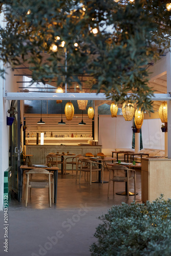 Luxury mediterranean restaurant dining room with warm lighting and decorative wicker pendant lamps