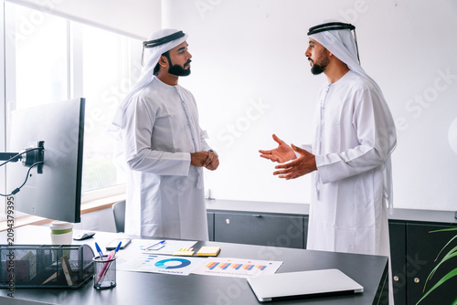 Canvas Print Arab businessmen discussing business strategy in modern office